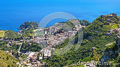 Aerial view of Taormina, on right is Castello Saraceno, in center is Ancient Greek theatre. Taormina located on Sicily island in Stock Photo