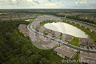 Aerial view of tightly packed homes in Florida closed living clubs with lake water in the middle. Family houses as Stock Photo