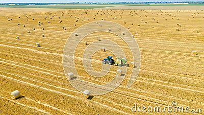 Aerial view of tractor tow trailed bale machine to collect straw from harvested field Editorial Stock Photo