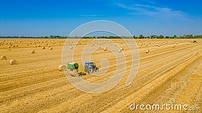 Aerial view of tractor tow trailed bale machine to collect straw from harvested field Editorial Stock Photo
