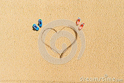 Aerial view of two pair of flip flops in shape of heart on sandy tropical beach. Valentines day. Holiday concept. Creative Stock Photo