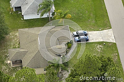 Aerial view of typical contemporary american private house with roof top covered with asphalt shingles and green lawn on Stock Photo
