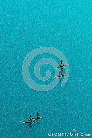 Aerial view of unrecognizable people stand up paddle boarding Stock Photo