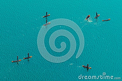 Aerial view of unrecognizable people stand up paddle boarding Stock Photo