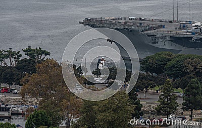 Aerial view of the USS Midway Aircraft Carrier`s bow and the Kissing Statue at the San Diego Museum, California Editorial Stock Photo