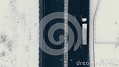 Aerial view vertically down the highway in winter, cars drive along the road Stock Photo