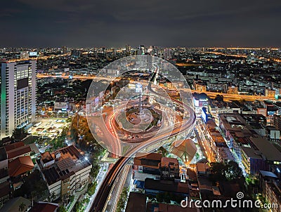 Aerial view of Victory Monument with car light trails on busy street road. Roundabout in Bangkok Downtown Skyline. Thailand. Editorial Stock Photo