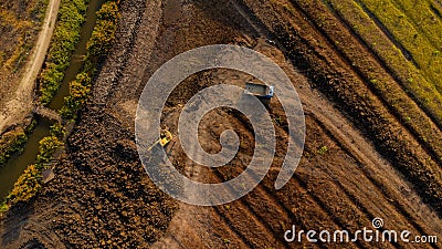 Aerial view of a wheel loader excavator with a backhoe loading sand onto a heavy earthmover at a construction site Stock Photo