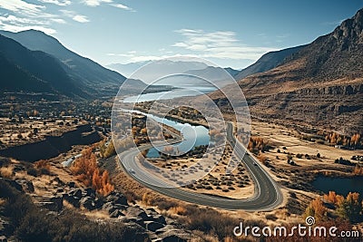 Aerial view of winding paved serpentine road next to river in scenic autumn mountains Stock Photo