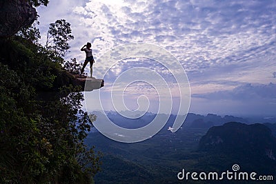 Aerial view of woman on the edge of the rock on the mountain view point Stock Photo