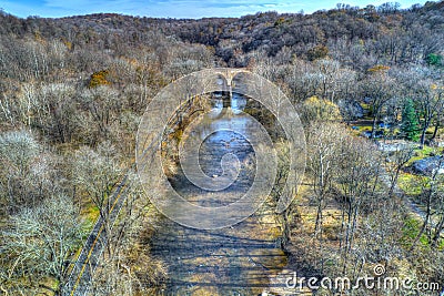 Aerial View of Woods in Fall Colors with a Road, Stream and Railroad Bridge Stock Photo