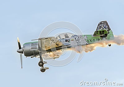 Aerobatic airplane pilot Jurgis Kairys training in the sky of the city. Colored airplane with trace smoke, airbandits, aeroshow Editorial Stock Photo