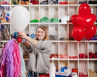 a woman inflates of helium from a white balloon. Stock Photo