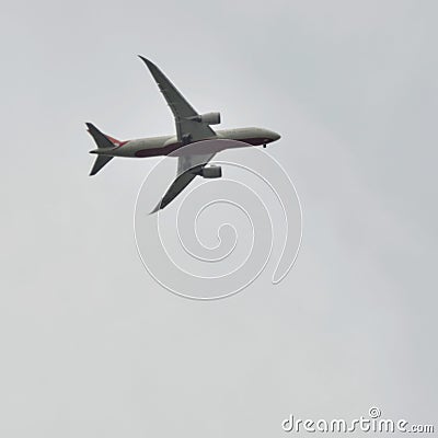 Aeroplane flying in the cloudy sky during the day time near Qutub Minar in Delhi India, Aeroplane flying high in the sky Stock Photo