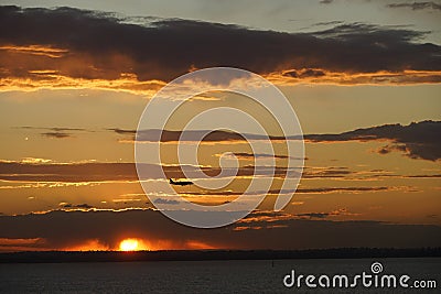 Aeroplane flying through sunset Stock Photo