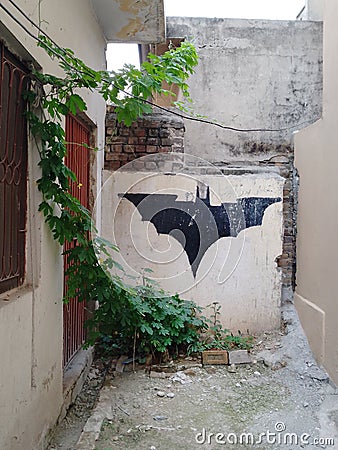 Aesthetic Batman logo on a wall with plantation Editorial Stock Photo