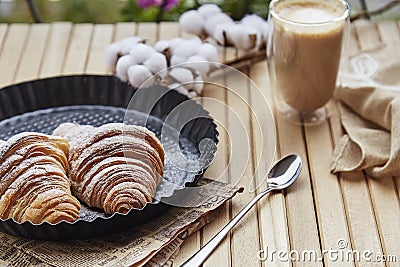Aesthetic French breakfast - crust fresh croissant with cup of latte at the terrace. Cotton decoration. Selective focus Stock Photo