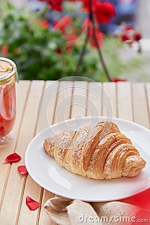 Aesthetic french croissant on the plate on the garden terrace. Copy space. Stock Photo