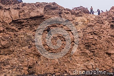 AFAR, ETHIOPIA - MARCH 26, 2019: Tourists climbing out of the Erta Ale volcano crater in Afar depression, Ethiop Editorial Stock Photo