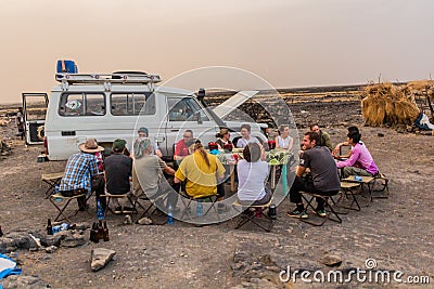 AFAR, ETHIOPIA - MARCH 25, 2019: Tourists eating in Dodom village under Erta Ale volcano in Afar depression, Ethiop Editorial Stock Photo