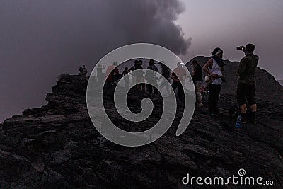AFAR, ETHIOPIA - MARCH 26, 2019: Tourists at the edge of Erta Ale volcano crater in Afar depression, Ethiop Editorial Stock Photo