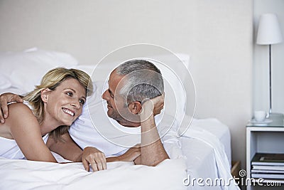 Affectionate Couple Relaxing On Bed Stock Photo