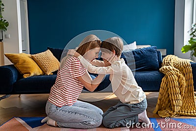 Affectionate empathic caring mom and teen son hug together sit on floor in living room at home. Stock Photo