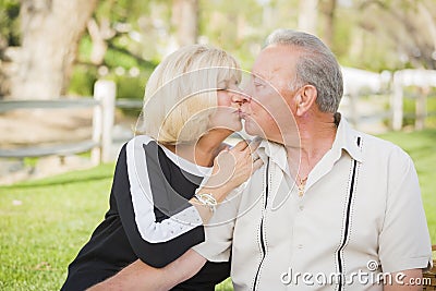 Affectionate Senior Couple Kissing At The Park Stock Photo