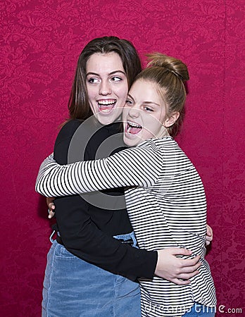 Affectionate teenage sisters yelling with mouths wide open. Stock Photo