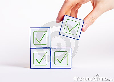 Affirmative unanimous decisions making. Hand holding cube with check mark. Voting, unity in thoughts, conformism Stock Photo