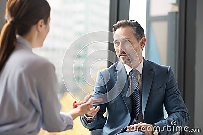 Affluent entrepreneur speaking with journalist while giving interview Stock Photo