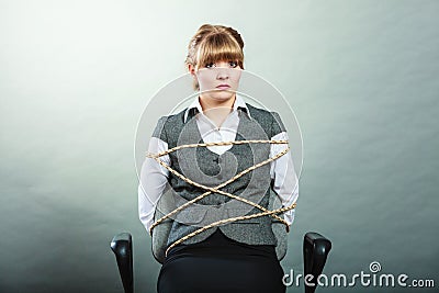 Afraid kidnapped woman tied with rope to chair. Stock Photo