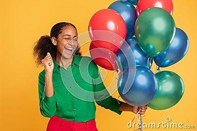 African adolescent girl posing with bright festive helium balloons, studio Stock Photo