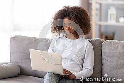 African adolescent girl sitting on couch using computer Stock Photo