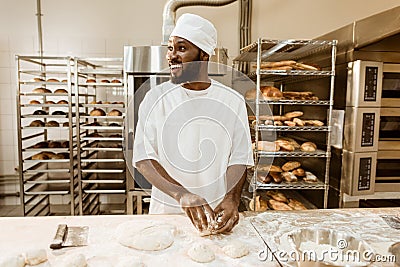 african american baker preparing raw dough for pastry Stock Photo