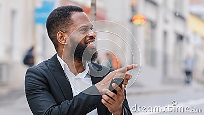 African American bearded man with smartphone navigation application GPS service lost in city looking for address with Stock Photo