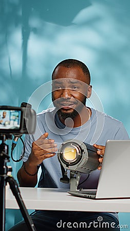 African american blogger reviewing studio light on camera Stock Photo