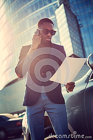 African american busi by smartphone and looking in to paper docu Stock Photo