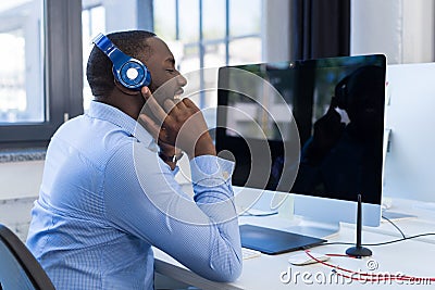 African American Businessman Listen To Music With Headphones In Modern Coworking Space, Adult Business Man Relaxing On Stock Photo