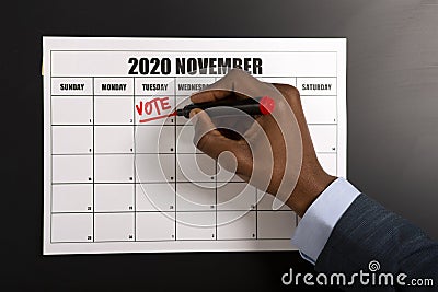 African american businessman writing Vote on November 3 Stock Photo