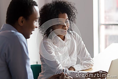 African American businesswoman mentor helping male trainee with project Stock Photo