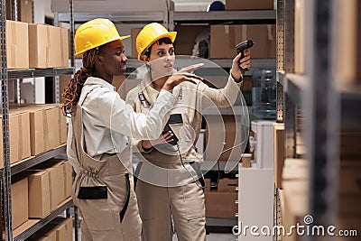 African american and caucasian warehouse operators scanning boxes barcodes Stock Photo