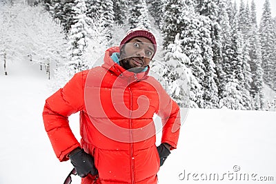 African American Cheerful black man in ski suit in snowy winter outdoors Stock Photo