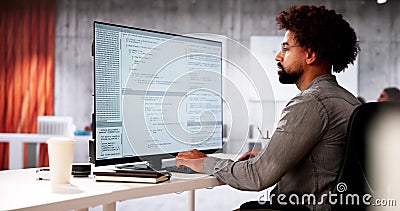 African American Coder Using Computer At Desk Stock Photo