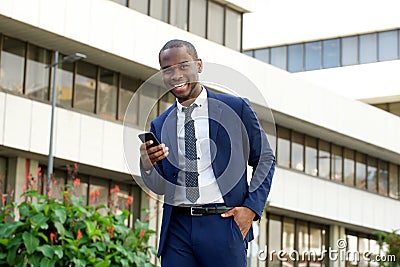 African american corporate businessman laughing with mobile phone in the city Stock Photo