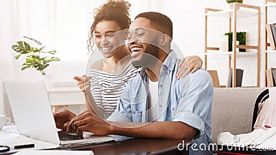 African-american couple searching tour online on laptop Stock Photo