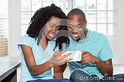 African american couple watching tv online on phone Stock Photo