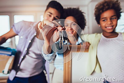 African American family is moving into a new apartment, they keep the keys from the apartment in their hands and look at the Stock Photo