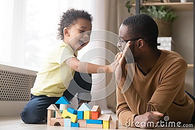 African American father with toddler son playing with wooden constructor Stock Photo