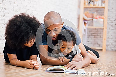 African American father reading a fairy tale fable story for kids at home Stock Photo